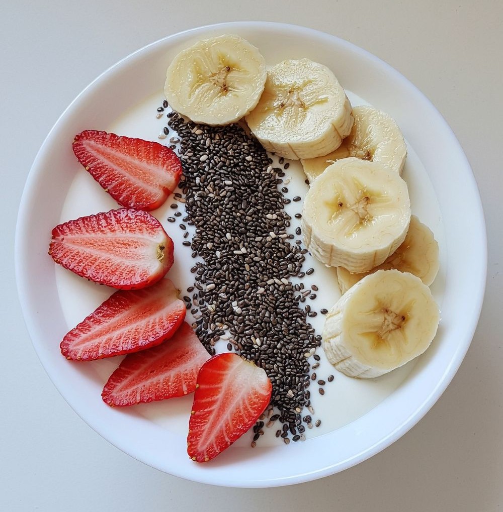Bowl of chia seeds with sliced strawberries and banana in milk