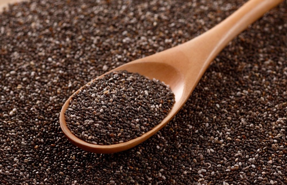 Close-up of raw chia seeds with a wooden spoon